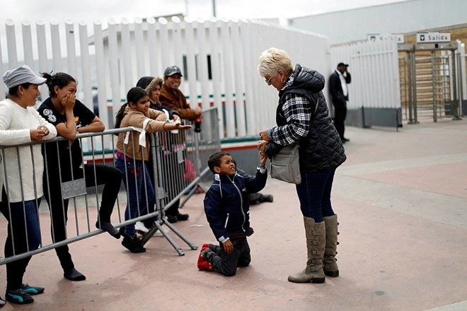 #foto #video Azilante, ki so obtičali na meji med Mehiko in ZDA, obdali z ograjo