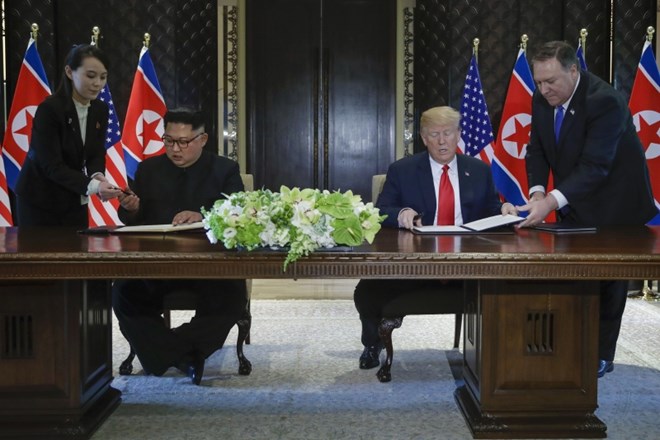 Kim Jong Un in Donald Trump med podpisom dokumentov.