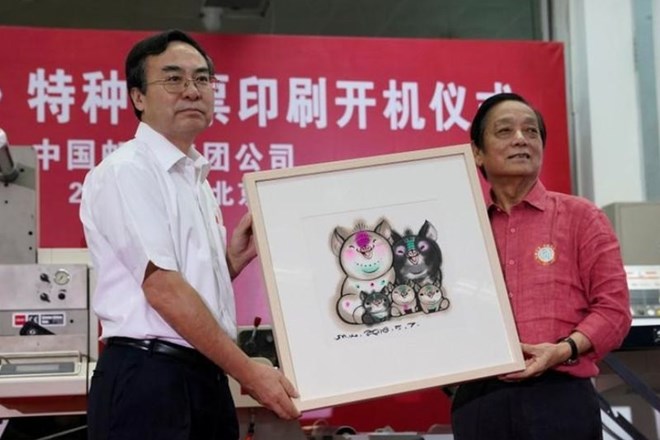 Oblikovalec znamke Han Meilin (desno) ob predsedniku podjetja China Post, Liu Ailiu, v Pekingu predstavlja znamko s prašičjo...