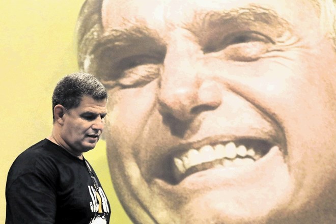 Zmagovalec prvega kroga predsedniških volitev Jair Bolsonaro se smeji s plakata. Obetal si je zmago v prvem krogu, a mu je...
