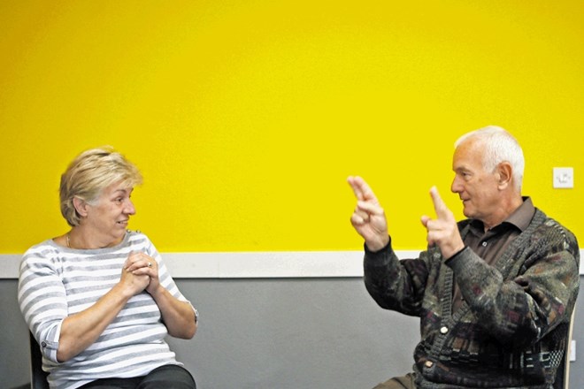 Direktorica Zavoda Združenje tolmačev za slovenski znakovni jezik Jasna Bauman v pogovoru z gluhonemo osebo