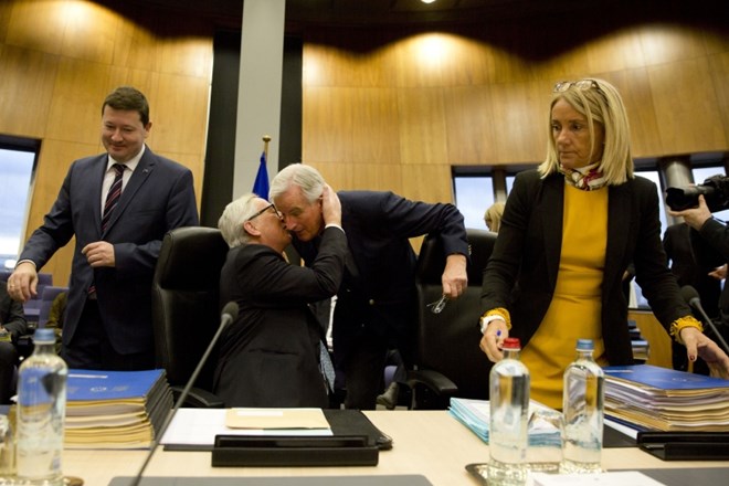 Predsednik Evropske komisije Jean-Claude Juncker (levo) pozdravlja pogajalca v zadevi brexit, Michela Berniera (desno).