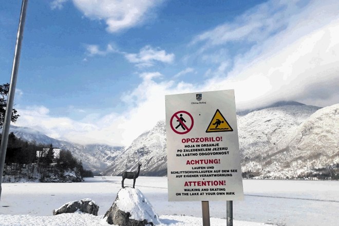 Table okoli Bohinjskega jezera v treh jezikih opozarjajo, da je hoja po zaledenelem jezeru nevarna.