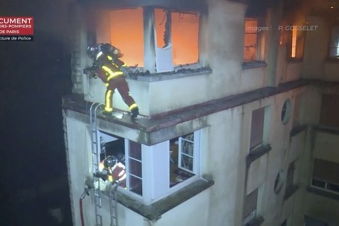 In this image taken from video released by the Paris Fire Dept., firemen scale the top floors of an apartment building on...