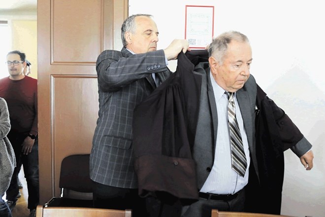 Pred razglasitvijo sodbe je takrat še obtoženi Milko Novič takole pomagal odvetniku Jožetu Hriberniku obleči togo.
