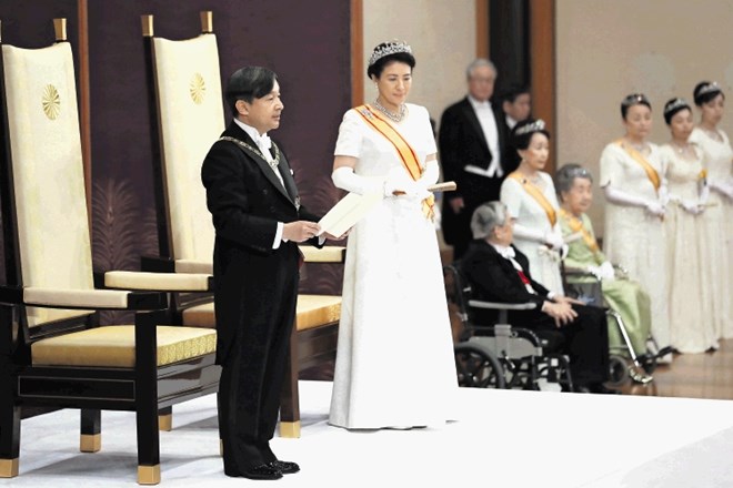 Prizor s   slovesnosti ob zamenjavi na prestolu: novi cesar Naruhito prvič nagovarja podložnike, ob njem stoji žena Masako.