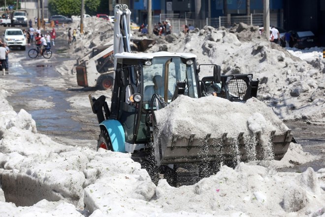 Kupe ledu, ki jih je s seboj prinesla huda nevihta, so s cest čistili tudi s traktorji.