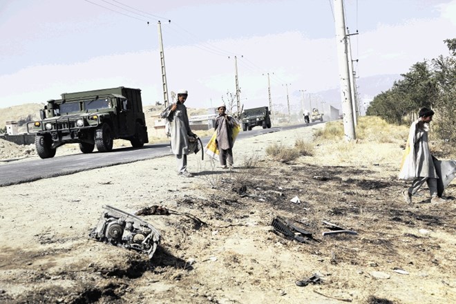 Lokalni prebivalci odnašajo ostanke z mesta napada na hrvaške vojake pri Kabulu.