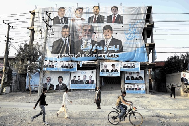 Pročelje nedokončane hiše v predmestju Kabula so pokrili predvolilni plakati predsedniškega kandidata Abdulaha Abdulaha.