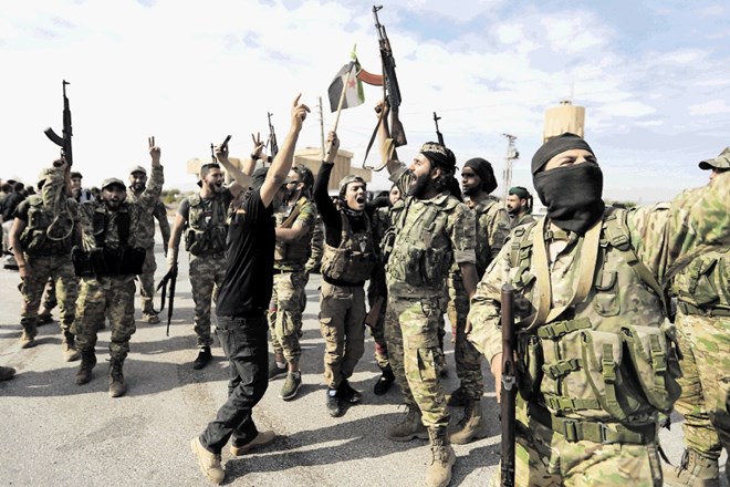 Pripadniki Svobodne sirske vojske, ki jo podpira Turčija, slavijo svoj prihod v obmejno mesto Tel Abjad.