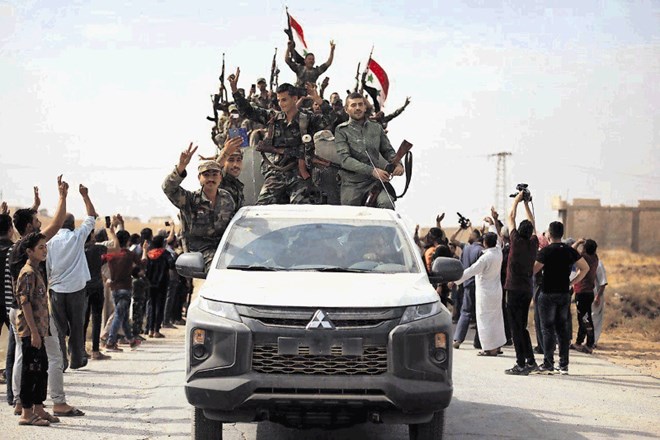 Pripadniki sirske vladne vojske mahajo z zastavami ob vstopu v mestu Ain Isa, kjer jih je pričakala dobrodošlica.
