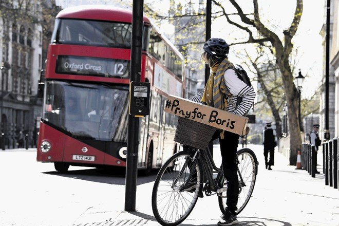 Londončanka  na kolesu prevaža napis s pozivom k molitvi za Johnsona.