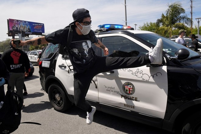 Protestnik brca v policijski avto v Los Angelesu.