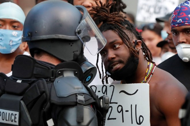 Moški prigovarja policistu med demonstracijami v Raleighu v Severni Karolini.