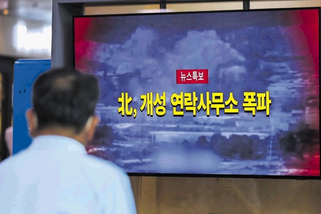 Moški v Seulu gleda poročila z novicami in posnetki razstrelitve urada.