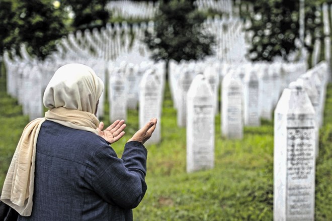 Ženska moli ob spominskem obeležju v Potočarih pri Srebrenici.