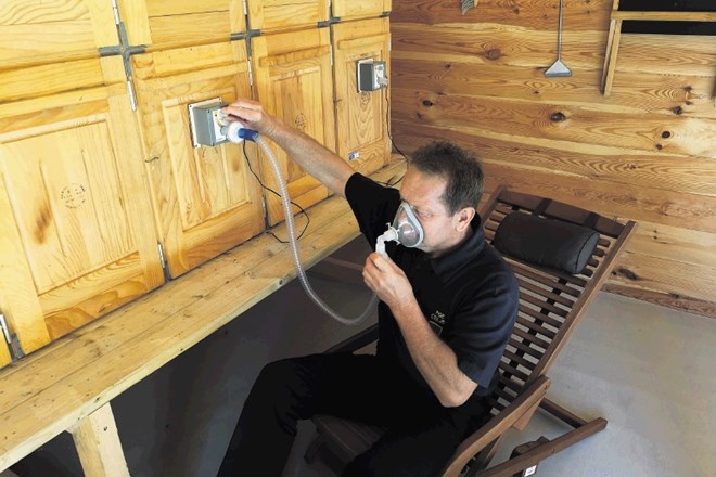 Gasilec Jože Plešnik demonstrira apiterapijo v gasilskem čebelnjaku v Celju.