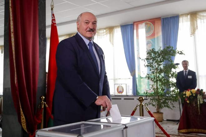 Beloruski predsednik Aleksander Lukašenko oddaja glas na volišču v Minsku.