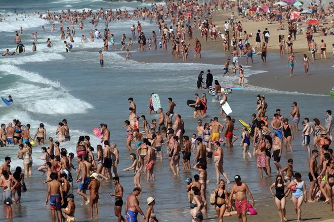 Turisti na plaži v francoskem Biarritzu včeraj popoldne.