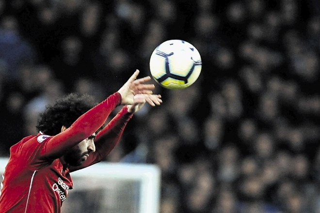 Nogometaš Liverpoola Mohamed Salah pri izvajanju žoge iz avta.