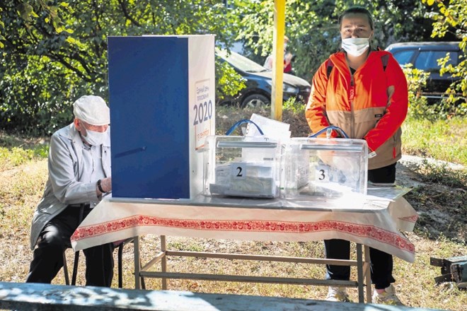 Moški izraža svoj glas na regionalnih volitvah na volišču, ki so ga v Tambovu v istoimenski pokrajini postavili kar na...