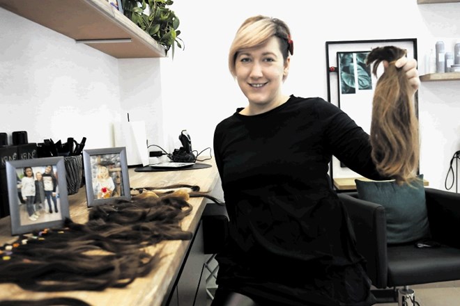 Brigita Smrekar s podarjenimi lasnimi čopi, iz katerih bodo izdelali lasulje za bolne otroke.