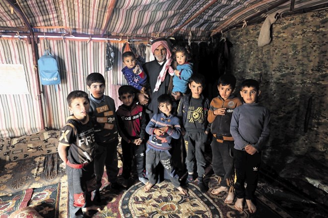 Abdel Razak Al Katun z devetimi vnuki in vnukinjami v svojem šotoru v taborišču za notranje razseljene Sirce v Idlibu.