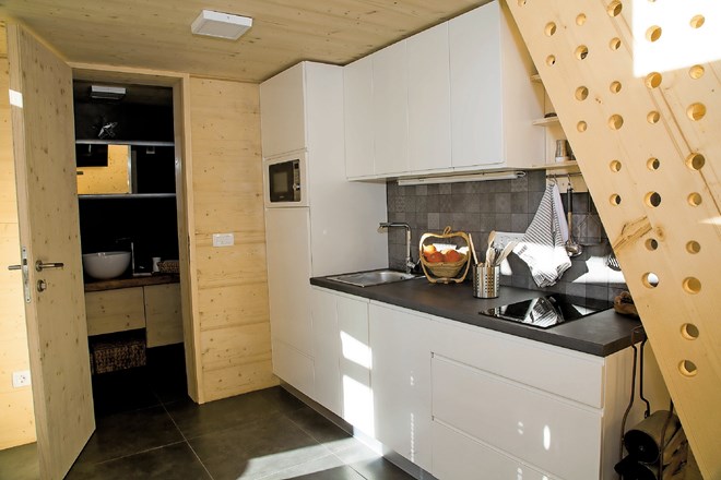 Kuhinja je minimalistična, pa vendar opremljena tako s kuhalno ploščo kot z mikrovalovno pečico in pomivalnim strojem.