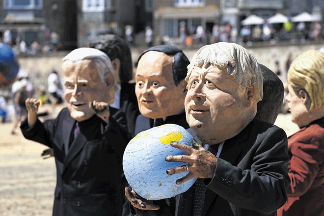 Protestniki z velikimi naglavnimi maskami svetovnih voditeljev, ki so se na vrhu skupine G7 zbrali v angleškem Cornwallu,...