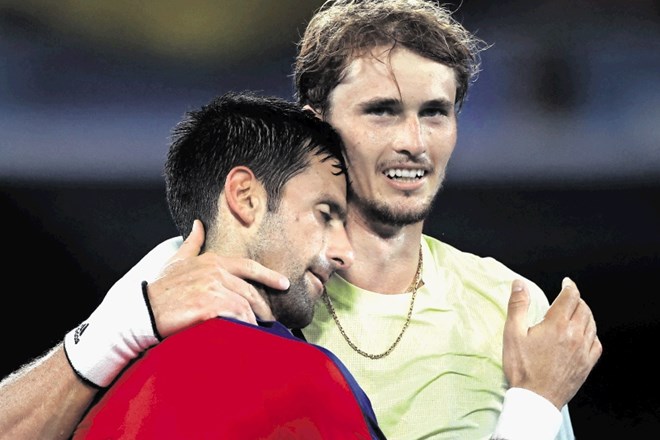 Razočarani Novak Đoković (levo) je tolažbo iskal tudi na ramenih tekmeca Alexandra Zvereva.