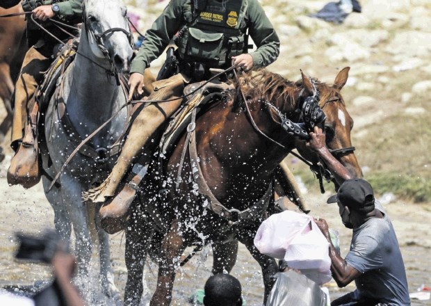 Policist na konju migrantu s Haitija preprečuje, da bi se iz reke Rio Grande vrnil v ZDA iz Mehike, kamor hodijo ljudje, ki...
