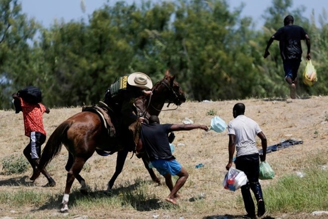 Policist na konju migrantu s Haitija preprečuje, da bi se iz reke Rio Grande vrnil v ZDA iz Mehike, kamor hodijo ljudje, ki...