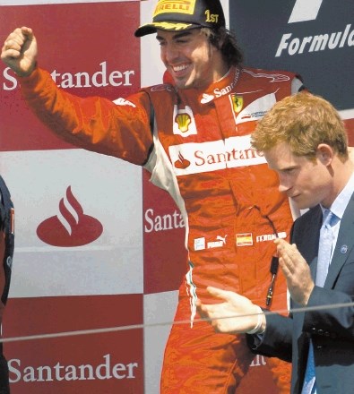 Britanski princ Harry (desno) je moral za zmago v Silverstonu zaploskati  dirkaču Ferrarija Fernandu Alonsu, čeprav je upal...