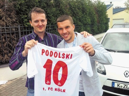 Lukas Podolski (desno) si je vzel nekaj minut svojega časa in  s podpisanim   dresom v roki poziral z Dnevnikovim...