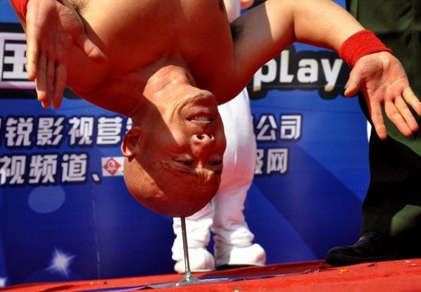 Kitajski kaskader že dvajset let izvaja stojo na glavi na želecni bodici.