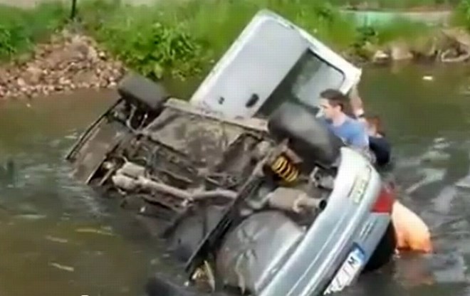 Gledalci so hitro priskočili na pomoč dirkačema, ki sta z avtomobilom pristala v vodi.