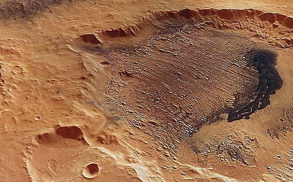 En krater razkriva temne lise sedimentnih kamnin.