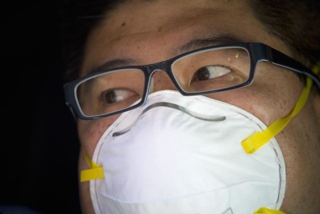 Pred zadušljivim zrakom se skušajo zaščititi s kirurškimi maskami. (Foto: Reuters) 