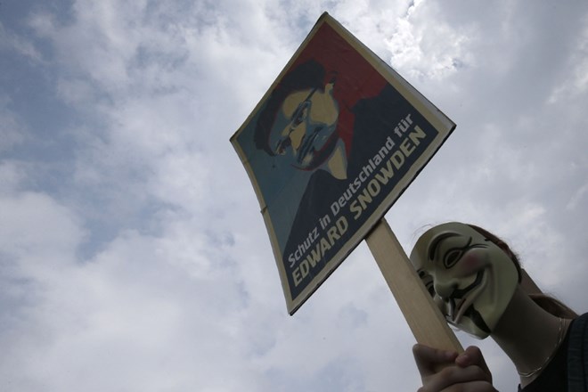 Protestnik s sliko Edwarda Snowdna.    