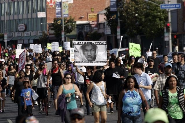 Protestniki s podobo temnopoltega najstnika Trayvona Martina. 
