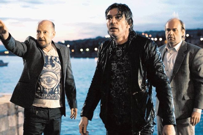 Hotelir Maks (Peter Musevski, ki kaže s prstom) zaman prepričuje nekdanjega rockerskega zvezdnika (Senad Bašić, na sredi),...