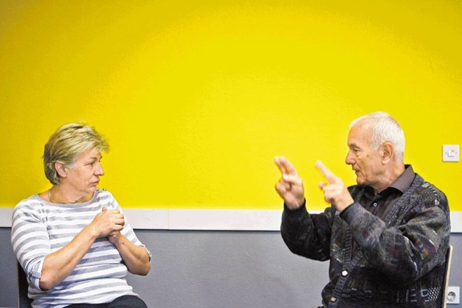Jasna Bauman, direktorica Združenja tolmačev za slovenski znakovni jezik, v pogovoru z gluho osebo. 