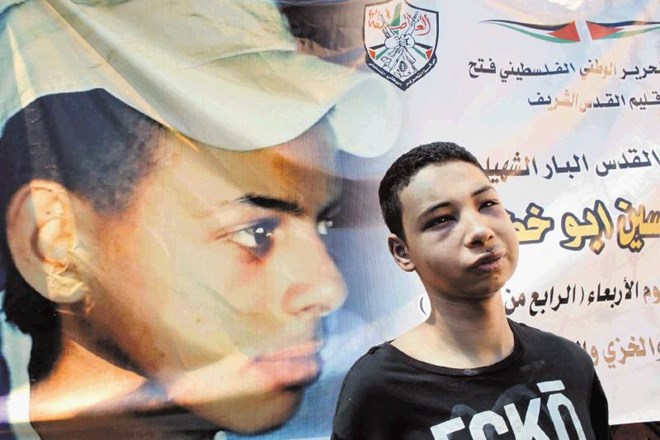 Brutalno pretepeni Tarik Kdejra ob sliki svojega bratranca Mohameda, ki so ga živega zažgali  izraelski skrajneži. 