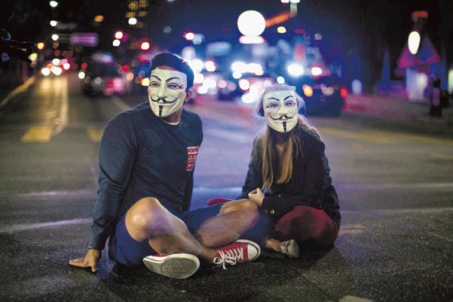 Aktivista v Los Angelesu z maskama tiho protestirata proti odločitvi porote. Reuters 