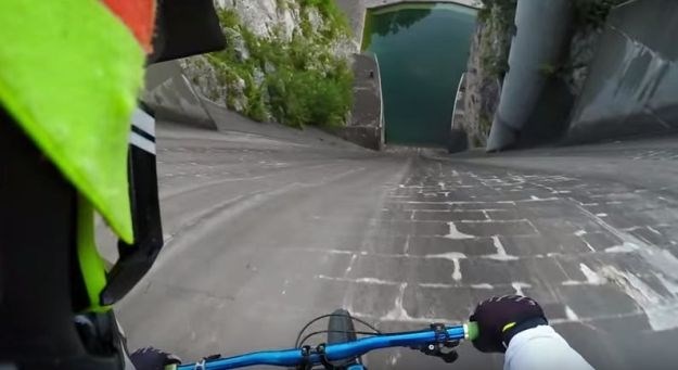 Nori Slovenec s kolesom po jezu hidroelektrarne 60 metrov v globino