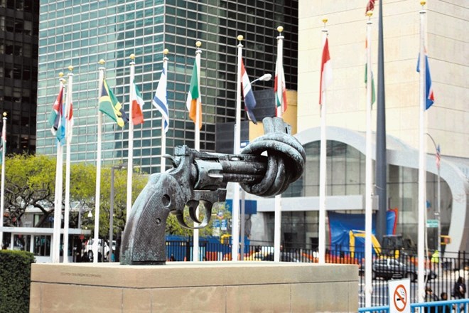 Zavezana pištola pred poslopjem OZN, kjer bodo tudi letos veliko govorili o potrebi po miru. Pred njo vihrajo zastave, ki se...