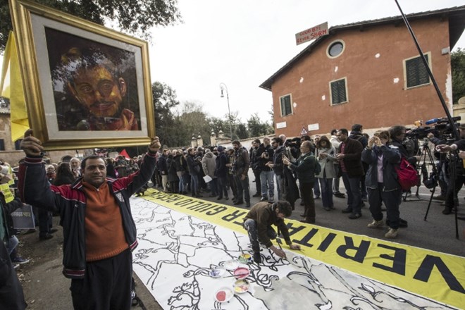 Protest pred egiptovskim veleposlaništvom v Rimu: Moški drži portret Giulia Regenija, italijanskega študenta, ki so ga ubili...