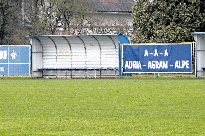 Ob robu igrišča nogometnega kluba Savski Marof se sveti napis z imenom Kramarićeve družbe Adria-Agram-Alpe,  tudi igralci so...