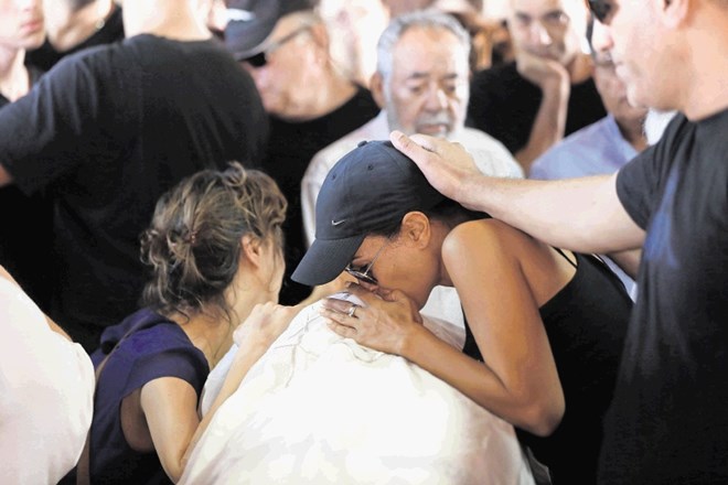 Sorodniki se poslavljajo od ene izmed žrtev strelskega napada v Tel Avivu.