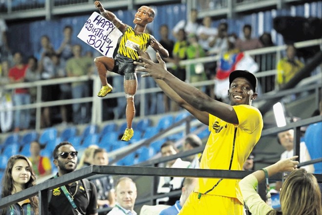 Usain Bolt je včeraj praznoval 30. rojstni dan, kar ponazarja tudi njegova maskota, ki jo drži v rokah.